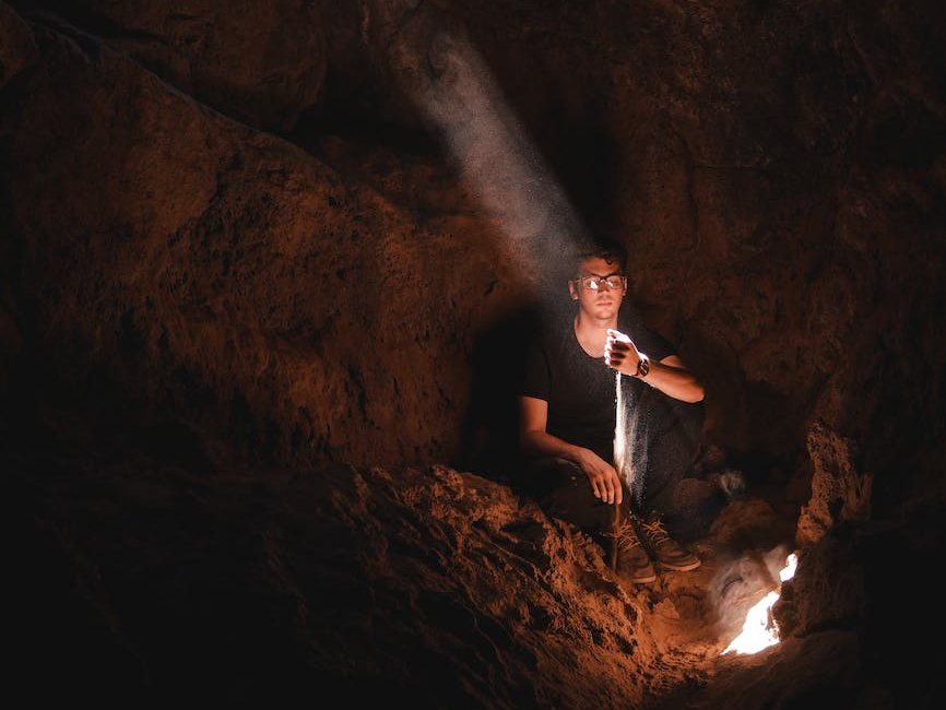 photo of man sitting inside cavee